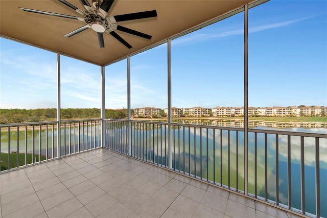 unfurnished sunroom with ceiling fan and a water view