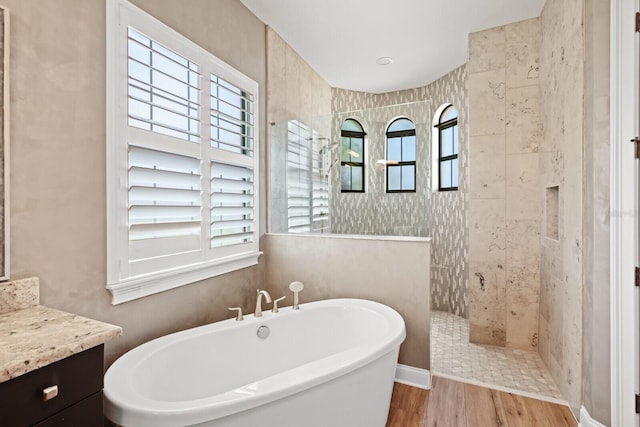 bathroom featuring shower with separate bathtub, hardwood / wood-style flooring, and vanity