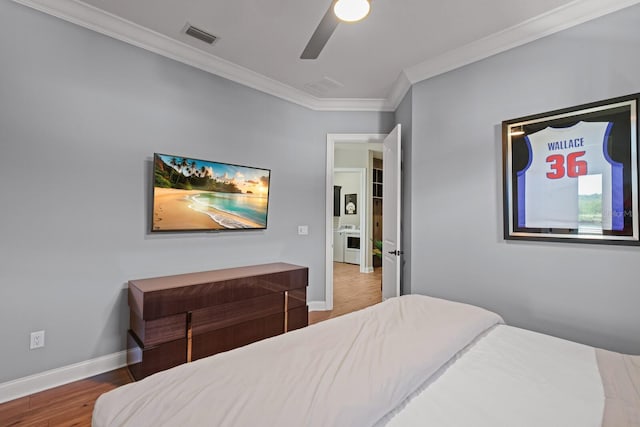 bedroom featuring ornamental molding, wood-type flooring, ceiling fan, and washer / clothes dryer