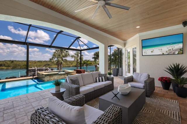 exterior space featuring glass enclosure, a swimming pool with hot tub, an outdoor living space, a water view, and ceiling fan