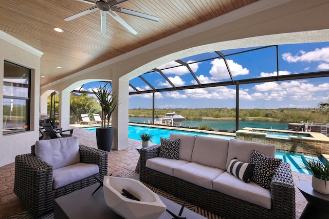 view of patio featuring a water view, a swimming pool with hot tub, an outdoor living space, ceiling fan, and glass enclosure