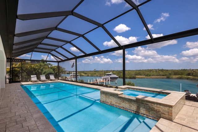 view of swimming pool featuring glass enclosure, a water view, a patio, and an in ground hot tub