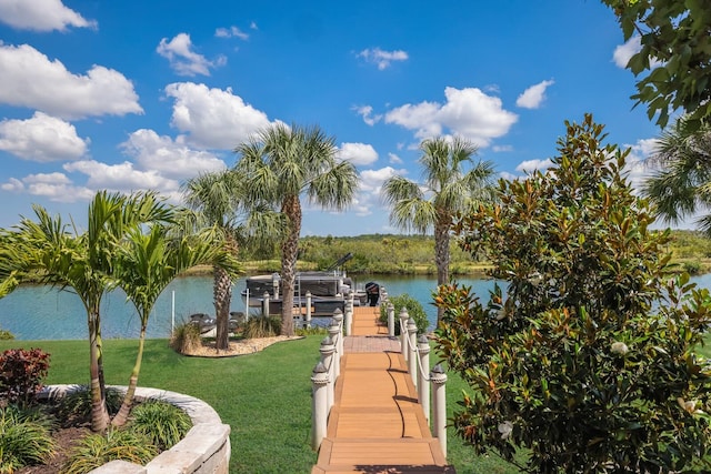 view of dock with a water view and a lawn