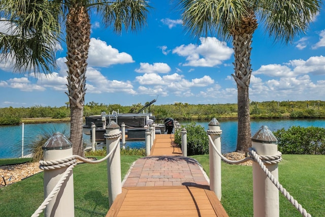 dock area with a lawn and a water view