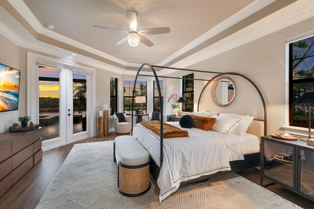 bedroom featuring hardwood / wood-style flooring, ceiling fan, a raised ceiling, crown molding, and access to outside