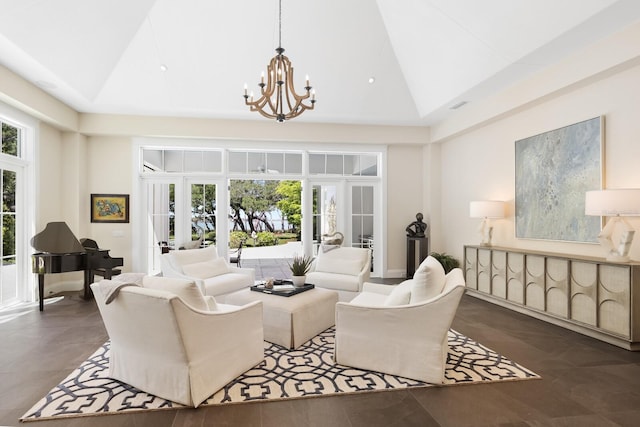 living room with french doors, lofted ceiling, a tray ceiling, and a notable chandelier