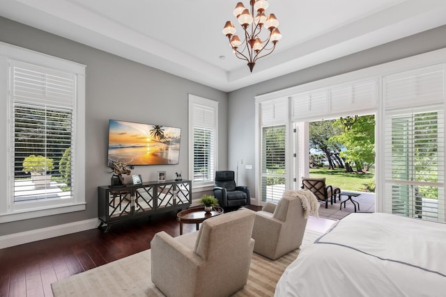 bedroom featuring access to exterior, wood-type flooring, and an inviting chandelier