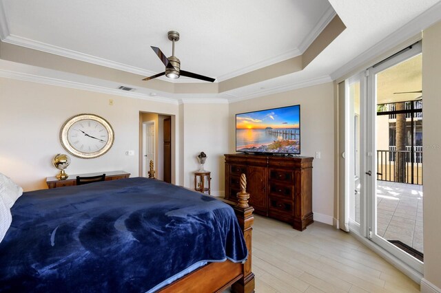 bedroom with ceiling fan, a raised ceiling, access to outside, ornamental molding, and light hardwood / wood-style flooring