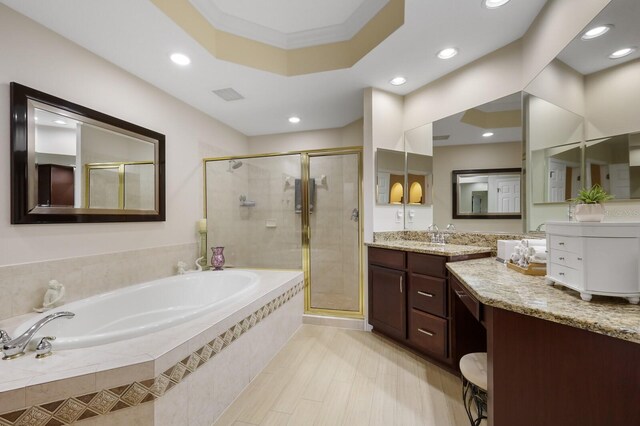 bathroom with tile flooring, independent shower and bath, a raised ceiling, crown molding, and vanity