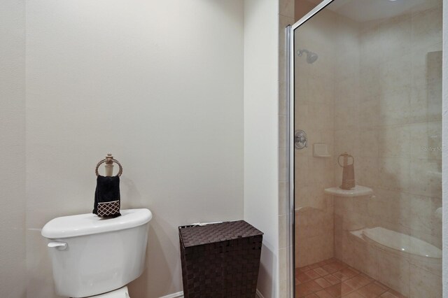 bathroom with a shower with shower door and toilet