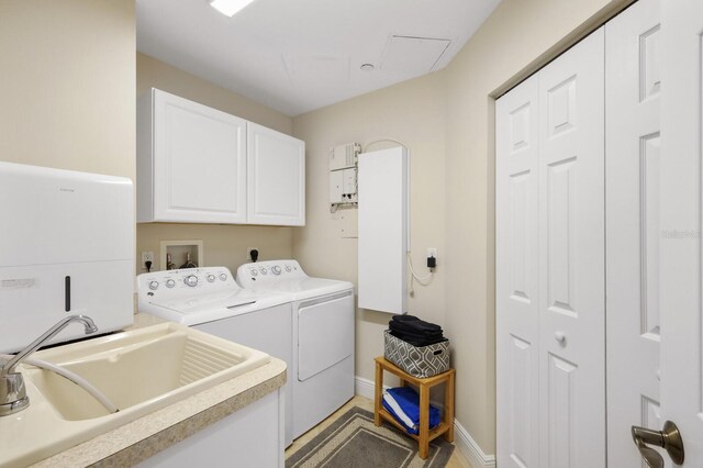 clothes washing area with cabinets, washing machine and clothes dryer, washer hookup, electric dryer hookup, and sink