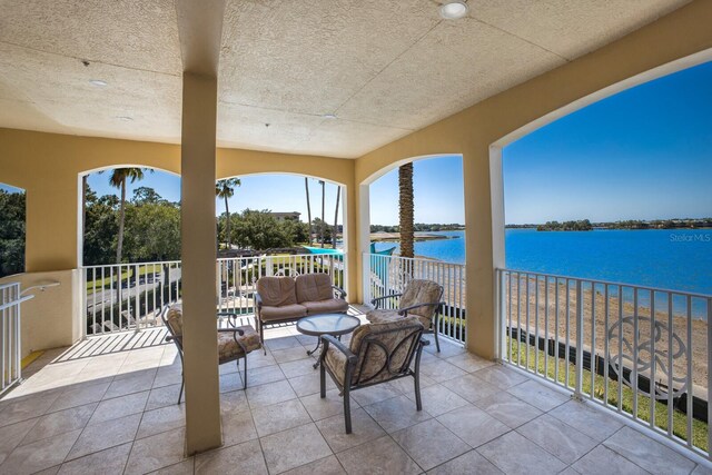 view of terrace with a balcony and a water view