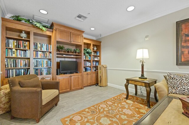 living area featuring ornamental molding and a textured ceiling