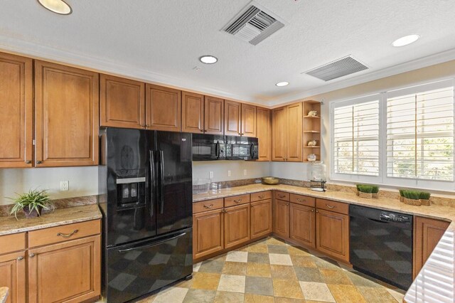 kitchen with light stone countertops, crown molding, light tile flooring, black appliances, and a textured ceiling