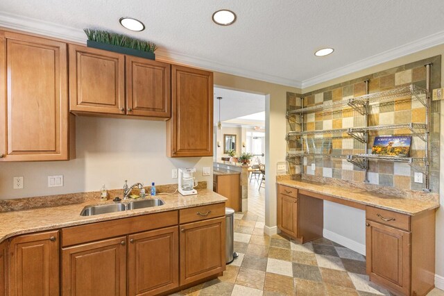 kitchen featuring light stone counters, sink, light tile floors, and ornamental molding