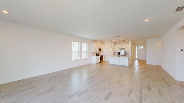 unfurnished living room with light wood-type flooring