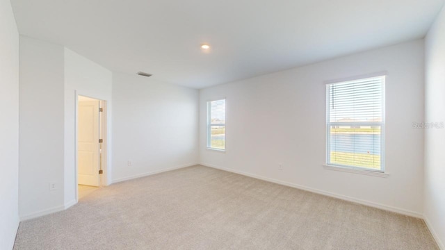 unfurnished room with plenty of natural light and light colored carpet