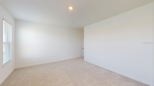 unfurnished room featuring light colored carpet