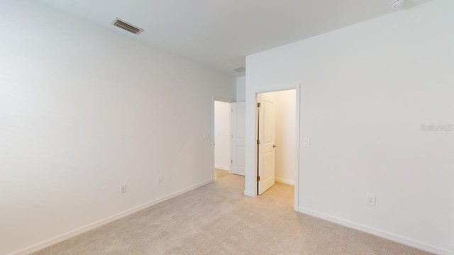 unfurnished room featuring light colored carpet