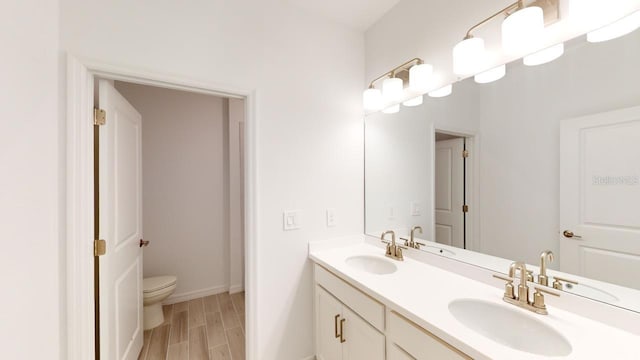 bathroom featuring hardwood / wood-style floors, vanity, and toilet