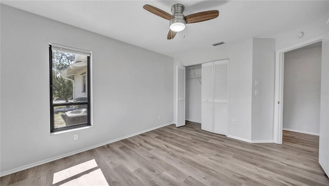 unfurnished bedroom with light hardwood / wood-style flooring, ceiling fan, and a closet