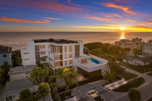 aerial view at dusk featuring a water view