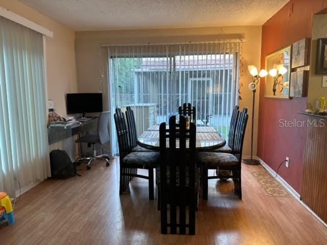 dining space featuring a textured ceiling and hardwood / wood-style flooring