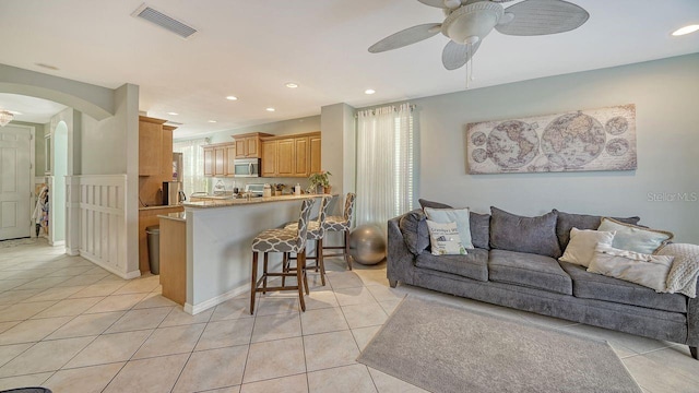 tiled living room with ceiling fan