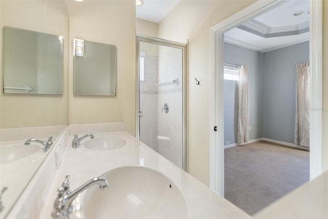 bathroom with ornamental molding, vanity, a tray ceiling, and a shower with shower door