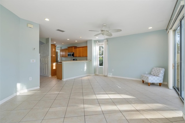 unfurnished living room featuring ceiling fan and light tile patterned floors