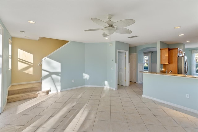 tiled spare room featuring ceiling fan