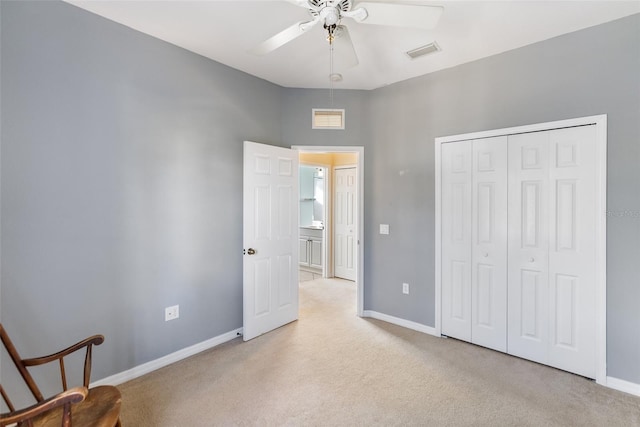 unfurnished bedroom featuring ceiling fan, a closet, and light carpet