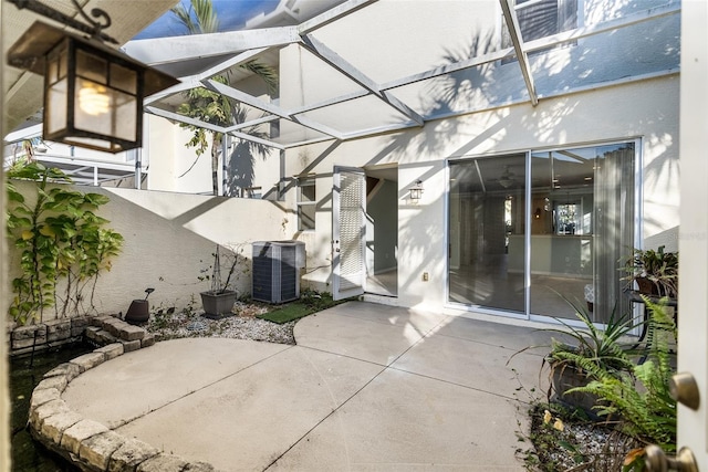 view of patio with cooling unit and glass enclosure