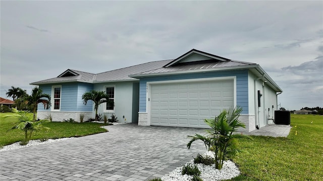 ranch-style home with a front yard, central air condition unit, and a garage