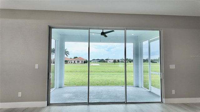 doorway to outside with a healthy amount of sunlight, light hardwood / wood-style floors, and ceiling fan