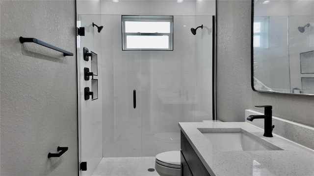 bathroom featuring vanity, an enclosed shower, and toilet