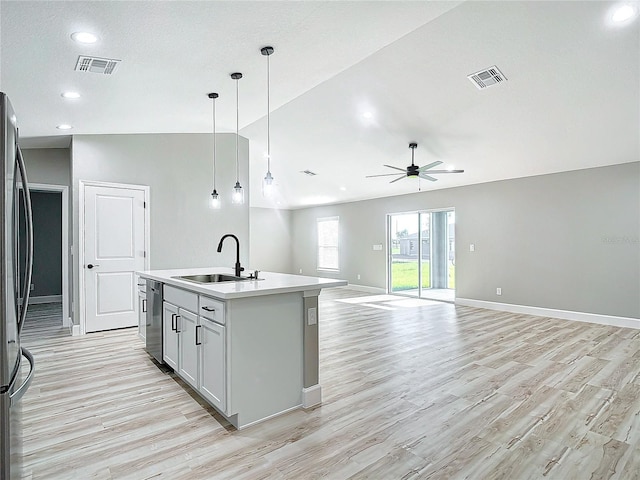 kitchen with an island with sink, light hardwood / wood-style flooring, ceiling fan, decorative light fixtures, and sink