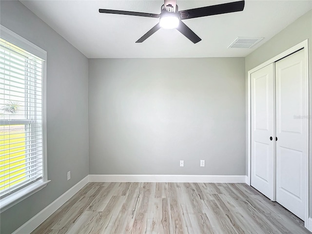 unfurnished bedroom featuring ceiling fan, a closet, and light hardwood / wood-style floors