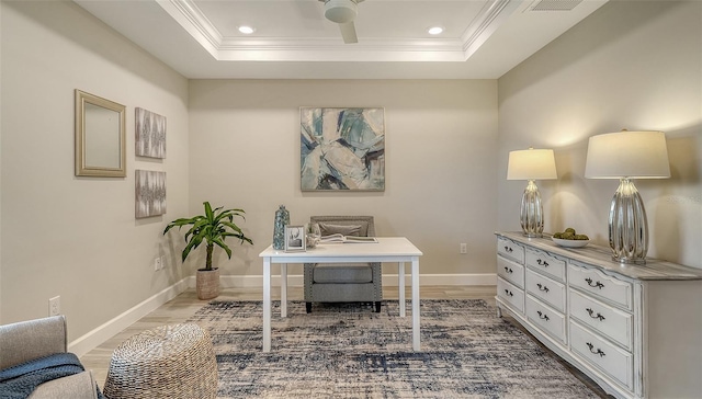 home office featuring wood-type flooring, ceiling fan, a tray ceiling, and ornamental molding