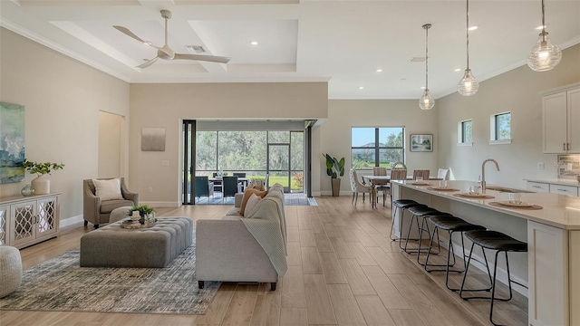 living room with coffered ceiling, sink, light wood-type flooring, beam ceiling, and ceiling fan