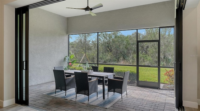 sunroom featuring ceiling fan and plenty of natural light