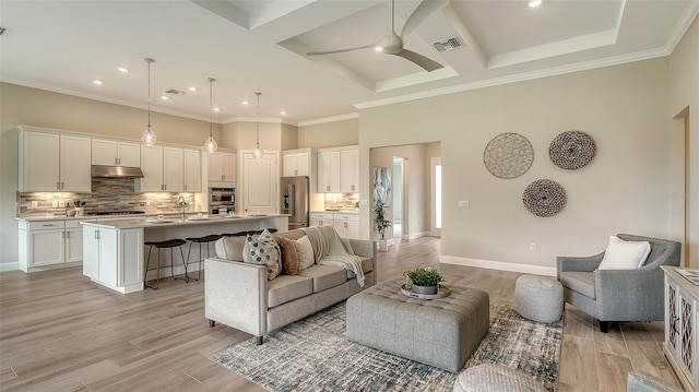 living room featuring coffered ceiling, light hardwood / wood-style flooring, a towering ceiling, and ceiling fan