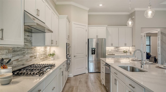 kitchen with white cabinetry, sink, decorative light fixtures, stainless steel appliances, and light stone counters