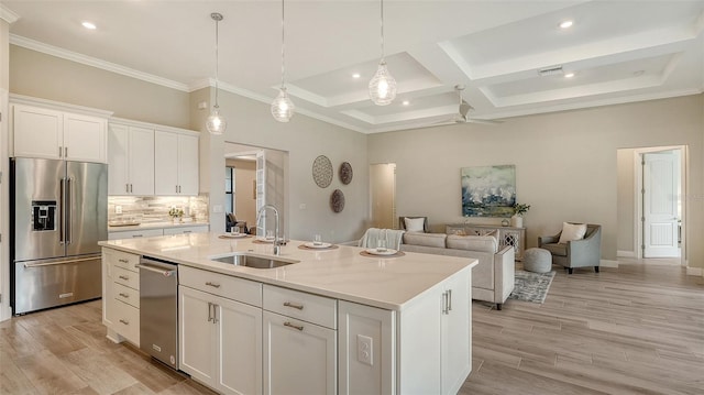 kitchen featuring decorative light fixtures, white cabinetry, an island with sink, sink, and high end fridge