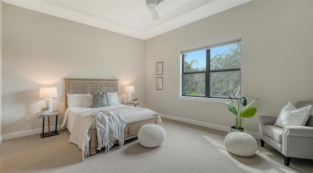 carpeted bedroom with a tray ceiling and ceiling fan