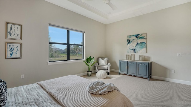 bedroom with ceiling fan, a raised ceiling, and light colored carpet