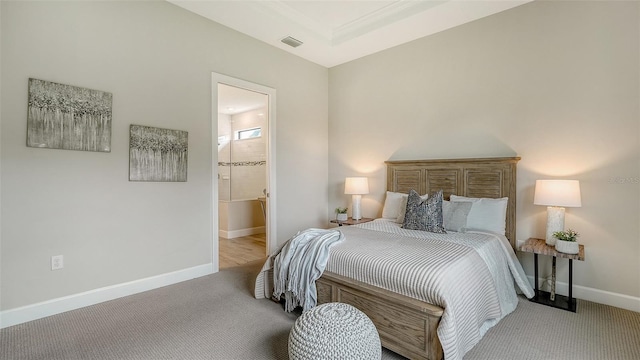 bedroom with light colored carpet and ensuite bath