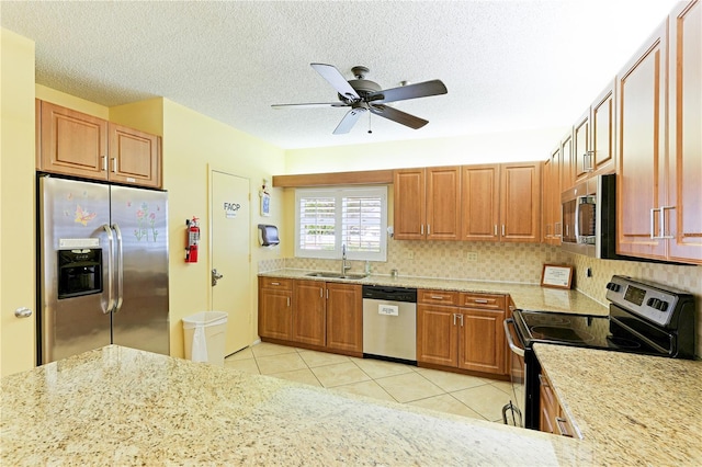 kitchen featuring sink, ceiling fan, decorative backsplash, light tile patterned floors, and stainless steel appliances