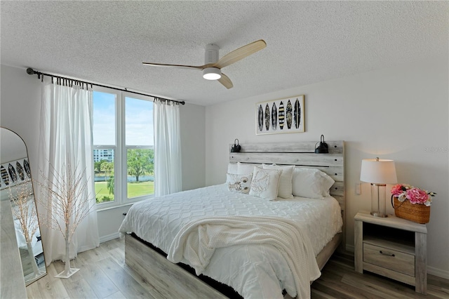 bedroom featuring hardwood / wood-style floors, a textured ceiling, and ceiling fan