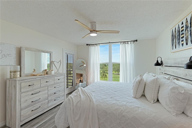 bedroom with ceiling fan, light wood-type flooring, and a textured ceiling